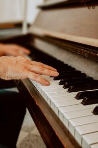 Hands gracefully playing piano keys, capturing musical passion and detail.