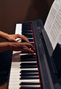 Hands elegantly play a modern electric keyboard, delivering captivating music indoors.