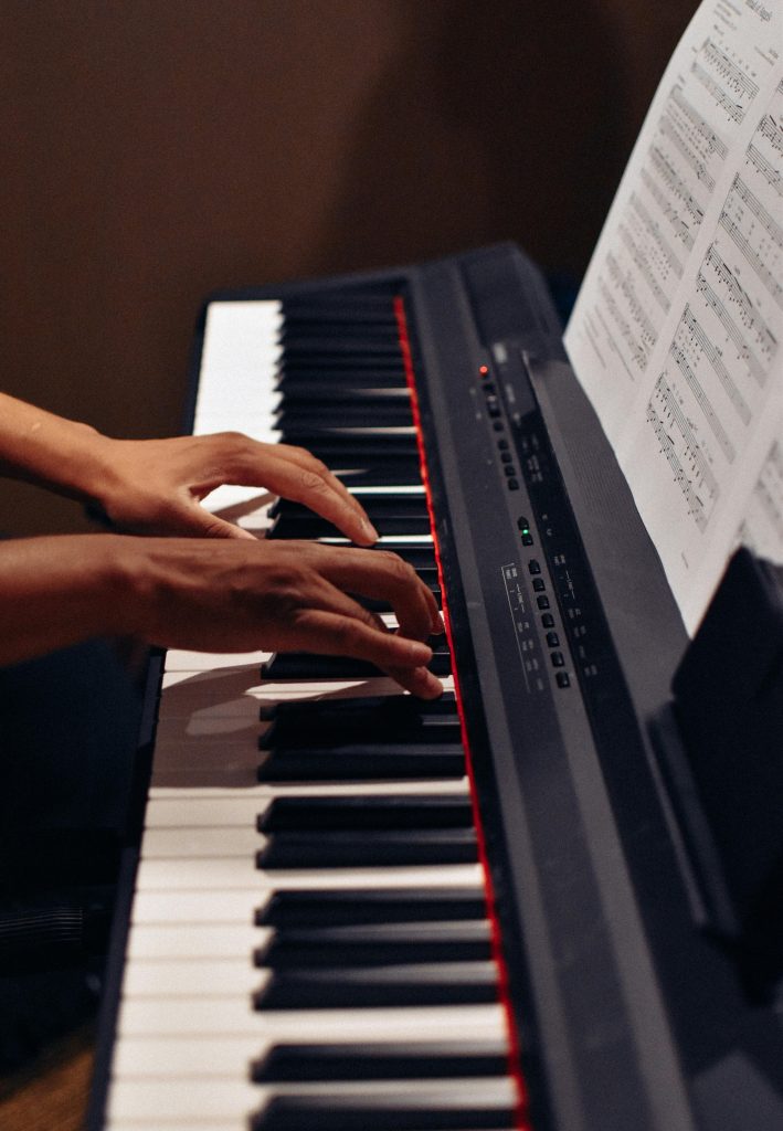 Hands elegantly play a modern electric keyboard, delivering captivating music indoors.